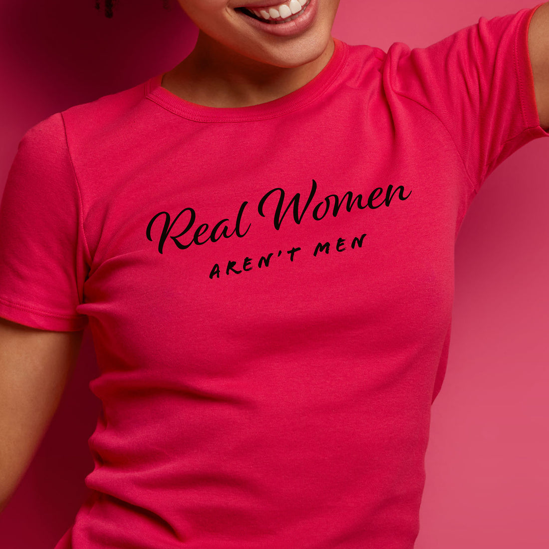 Womans torso wearing a red t-shirt that says Real Women Aren't Men.
