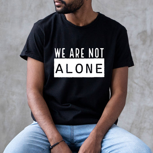 classic t-shirt with the words We Are Not Alone  in large print. white print available on dark color shirts and black print available on light color shirts.